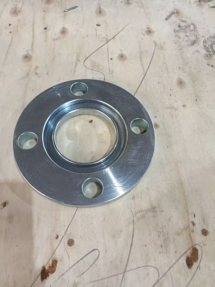 Chi tiết này là mặt bích ống trượt bằng thép carbon mạ kẽm – một phụ kiện đường ống thông dụng dùng để nối các đoạn đường ống. Nó có một lỗ rỗng ở giữa (được thiết kế để trượt qua các đầu ống để cố định bằng hàn) và bốn lỗ bu lông được bố trí đều xung quanh mặt bích phẳng, cho phép nó tạo ra các kết nối kín, không rò rỉ với các mặt bích tương ứng (khi sử dụng với gioăng và ốc vít).